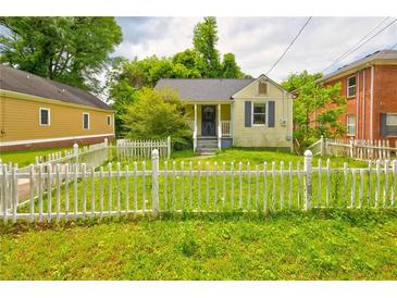 Charming home featuring a white picket fence and lush green lawn at 246 Stafford Nw St, Atlanta, GA 30314
