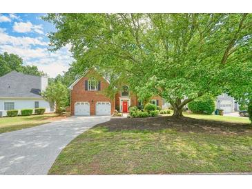 Charming two-story brick home with a well-manicured lawn and mature trees offering great curb appeal at 510 Morning Mist Ct, Alpharetta, GA 30022