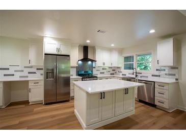 Bright kitchen features white cabinetry, stainless steel appliances and a center island with quartz countertops at 1342 Carter Rd, Decatur, GA 30030