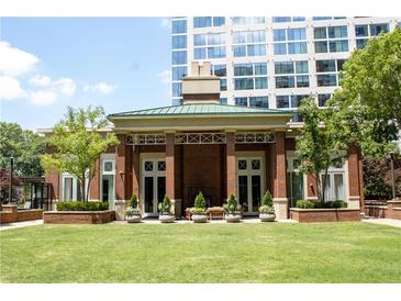 Beautiful clubhouse with brick facade, green roof, and lush landscaping sits in front of a modern high-rise building at 1820 Peachtree Nw St # 309, Atlanta, GA 30309