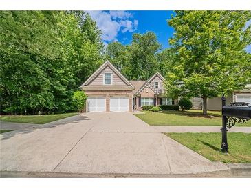 Charming two-story home featuring a well-maintained lawn and a convenient two-car garage at 2557 Woodford Ln, Buford, GA 30519