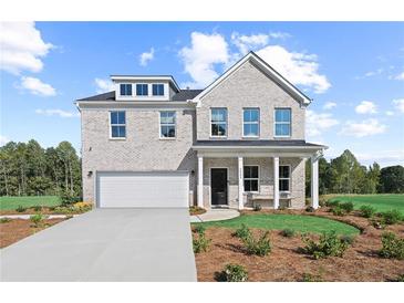 Beautiful two-story home with a light brick exterior, attached garage, and manicured front lawn at 1640 Tide Mill Rd, Cumming, GA 30040
