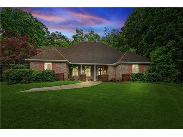 Charming brick home features a manicured lawn, mature trees, and a welcoming entrance for excellent curb appeal at 1275 Fontainebleau Ct, Lawrenceville, GA 30043