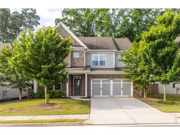 Charming two-story home with a brick and siding facade, well-manicured lawn, and an attached two-car garage at 333 Gardens Of Harmony Dr, Canton, GA 30115