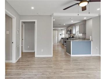 Open-concept living room with wood floors flows into kitchen with granite countertops at 2309 Carver Nw Dr, Atlanta, GA 30314