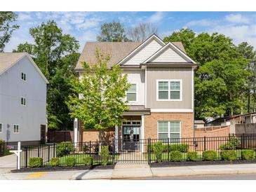 Charming two-story home boasts a brick facade, neutral siding, and a well-manicured front yard with a decorative fence at 2792 Mathews Se St, Smyrna, GA 30080