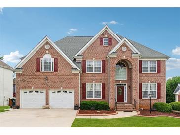 Charming two-story brick home with a well-manicured lawn, a two car garage and inviting front entrance at 2372 Wilshire Way, Douglasville, GA 30135