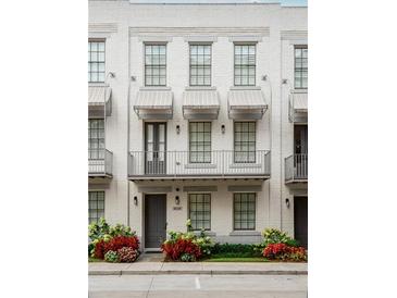 Charming three-story townhouse with a balcony, awnings, and beautiful landscaping at 312 Stonemont Dr, Atlanta, GA 30305