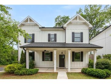 Charming two-story home with white siding, black shutters, and a welcoming front porch at 3123 Cedar St, Scottdale, GA 30079