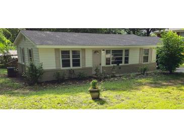 Charming single-story home with light-colored exterior, dark roof, and well-maintained front lawn at 50 Woodland St, Buford, GA 30518