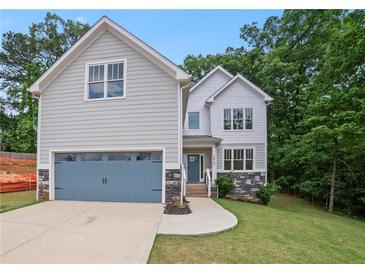 Charming two-story home with gray siding, stone accents, blue garage door, and a well-manicured front lawn at 2463 Whites Rdg, Decatur, GA 30034