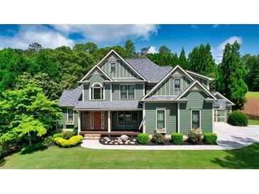 Charming two-story home with landscaped front yard and welcoming entrance, complemented by mature trees and lush greenery at 102 Cavit Ct, Canton, GA 30114