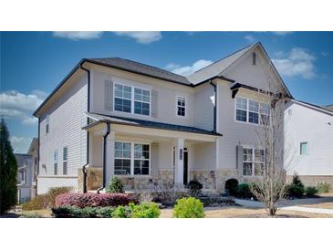 Charming two-story home features a stone-accented facade, covered porch and beautifully landscaped front yard at 3173 Rockbridge Rd, Avondale Estates, GA 30002
