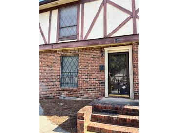 Charming townhome featuring brick facade, secure barred windows, and inviting front entrance at 3298 Abbeywood Dr, Decatur, GA 30034