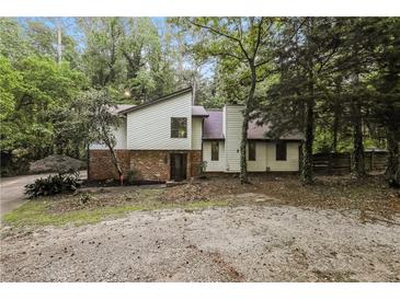 Charming two-story home with a brick accent and surrounded by mature trees and lush greenery at 600 Ponderosa Ct, Fayetteville, GA 30214