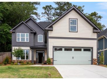 Charming two-story home featuring a stylish gray and cream exterior with a two-car garage and landscaped front yard at 2432 Whites Rdg, Decatur, GA 30034