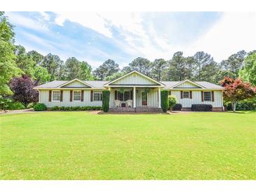 Charming ranch-style home with a manicured front yard and inviting covered porch at 2997 Happy Hollow Se Dr, Conyers, GA 30094