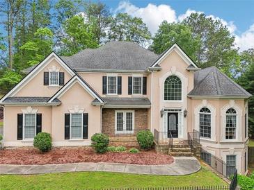 Stunning two-story home with a manicured front yard and elegant architectural details at 503 Kensington Estates Trce, Woodstock, GA 30188