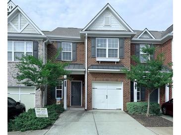 Charming brick townhome with a one car garage and well maintained front yard at 5620 Moresby Ct, Alpharetta, GA 30022