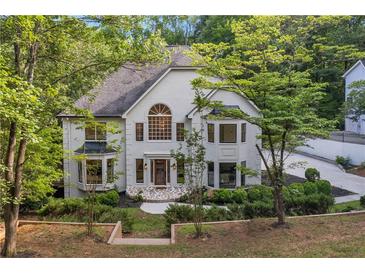 Two-story home with a stone entryway, large windows, and professionally landscaped front yard at 2655 Boulder Creek Ne Dr, Roswell, GA 30075