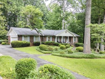 Charming brick home featuring manicured landscaping and a welcoming front yard with mature trees at 3792 Harts Mill Ne Ln, Brookhaven, GA 30319