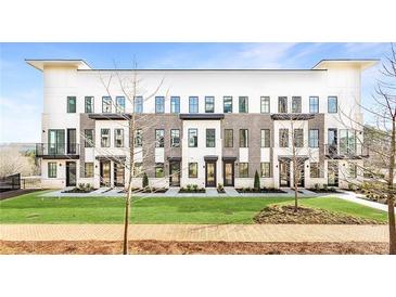 Modern townhome complex boasts a manicured lawn and elegant brick and white facade at 7130 Summit Pl, Alpharetta, GA 30009