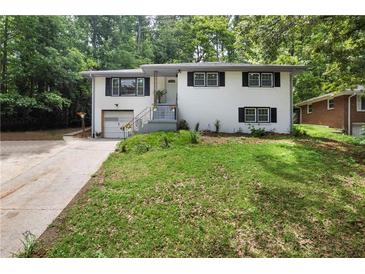 Charming two-story home with a white brick facade, black shutters, and well-maintained front yard at 3904 Bakers Ferry Sw Rd, Atlanta, GA 30331