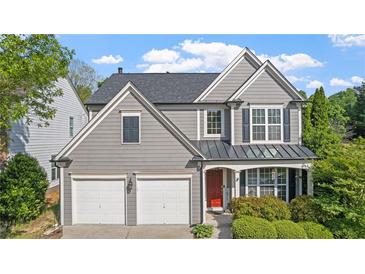 Charming two-story home featuring gray siding, a two-car garage, and a welcoming red front door at 3525 Elder Field Ln, Cumming, GA 30040