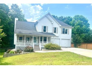 Charming two-story home featuring a cozy front porch and a well-maintained landscaped yard at 402 Hancock Ct, Woodstock, GA 30188