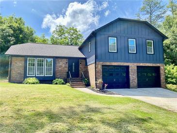 Beautiful two-story brick and blue home with a well-manicured front lawn and attached two-car garage at 323 W Claiborne Ct, Marietta, GA 30066