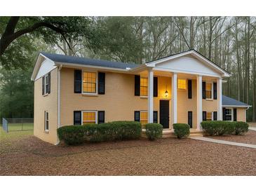 Charming two-story home featuring a columned porch, black shutters, and a well-maintained front lawn at 1607 Hillview, Jonesboro, GA 30236