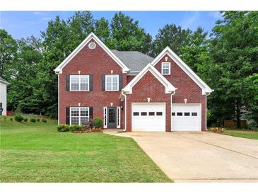 Charming two-story brick home featuring a well-manicured lawn and a two-car garage at 2994 Meadow Church Rd, Suwanee, GA 30024