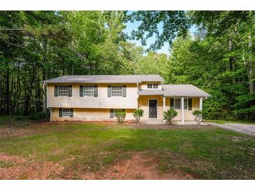 Charming, tree-surrounded split-level home with a freshly mowed yard at 1034 Sandy Ridge Rd, Mcdonough, GA 30252