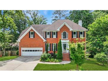 Beautiful two-story brick home with lush landscaping and a well-manicured lawn at 2641 Loch Way, Snellville, GA 30039