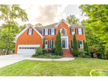 Beautiful two story brick home featuring a manicured lawn and an attached two-car garage at 2641 Loch Way, Snellville, GA 30039