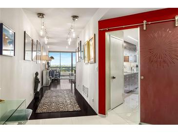 Bright hallway featuring hardwood floors, modern lighting fixtures, and a decorative sliding door at 2660 Peachtree Nw Rd # 13H, Atlanta, GA 30305