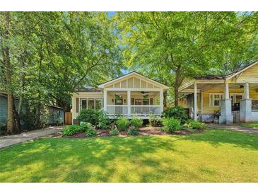 Charming bungalow with a welcoming front porch, mature trees, and lush landscaping at 1443 Metropolitan Se Ave, Atlanta, GA 30316