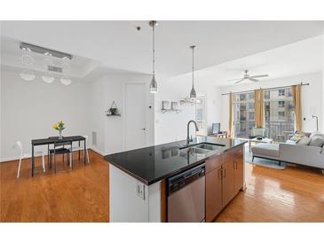 Bright, modern kitchen features stainless steel appliances, pendant lighting and an island with a sink at 711 Cosmopolitan Ne Dr # 300, Atlanta, GA 30324