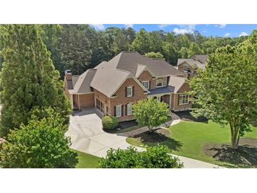 Stately brick home with lush landscaping, circular drive, and mature trees at 13037 Overlook Pass, Roswell, GA 30075