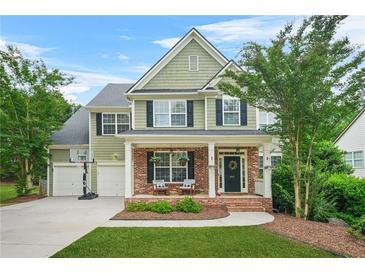 Charming two-story home with brick accents, covered porch, manicured lawn, and a two-car garage at 1037 Panoramic Pte, Buford, GA 30518
