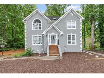 Charming two-story home with a gray stucco exterior and well-manicured front yard, steps leading to the front door at 959 Vendue Dr, Lawrenceville, GA 30044
