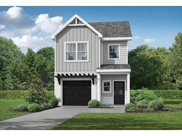 Charming two-story home with a modern gray exterior, a black garage door, and a well-maintained lawn at 27 Benscot Dr, Austell, GA 30106