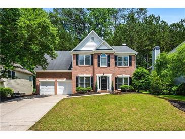 Charming two-story brick home featuring a well-manicured lawn and a two-car garage at 3174 Vickery Ne Dr, Marietta, GA 30066