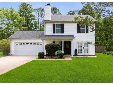 Charming two-story home featuring a well-manicured lawn, attached garage, and classic black shutters at 70 Fairclift Dr, Covington, GA 30016
