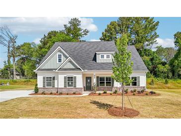 Charming single-story home features a welcoming front porch, green shutters, and landscaped yard at 1471 Stephens View Dr, Loganville, GA 30052