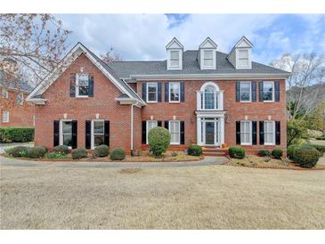 Beautiful two-story brick home featuring a well-manicured lawn and classic architectural details at 340 Kincardine Way, Alpharetta, GA 30022