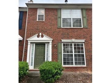 Charming brick townhouse with green door and shutters and mature bushes at 2653 Parkway Trl, Lithonia, GA 30058