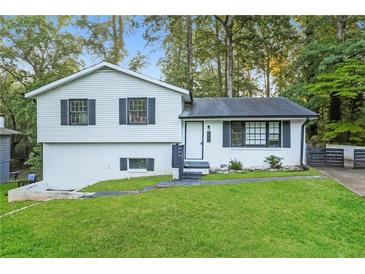 Charming split-level home with white exterior, black shutters, and well-manicured lawn at 6864 Maddox Rd, Morrow, GA 30260