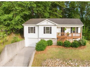Charming home featuring a neatly landscaped front yard, a driveway, and a cozy front porch at 306 Birch St, Canton, GA 30114