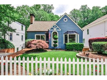 Charming blue two-story home with a manicured lawn, lovely landscaping, and a classic white picket fence at 2639 Acorn Ne Ave, Atlanta, GA 30305
